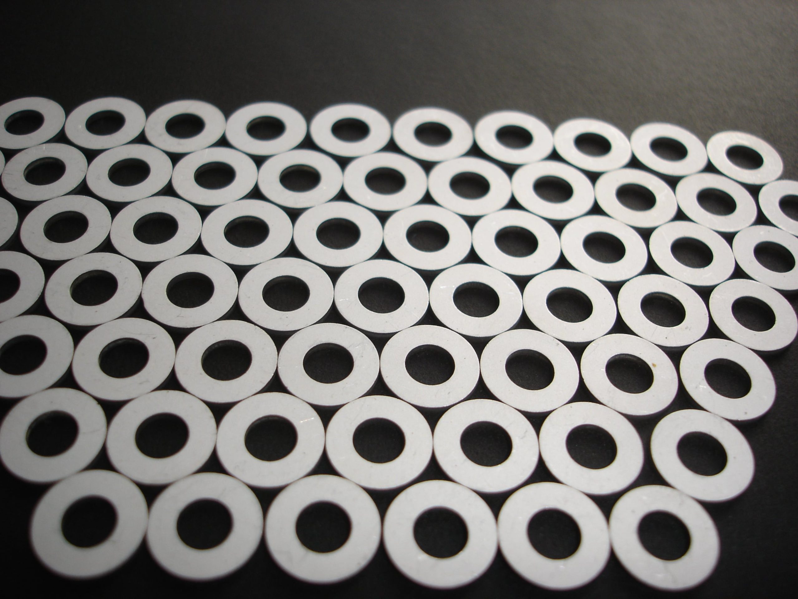 a bunch of white circles with holes in them
