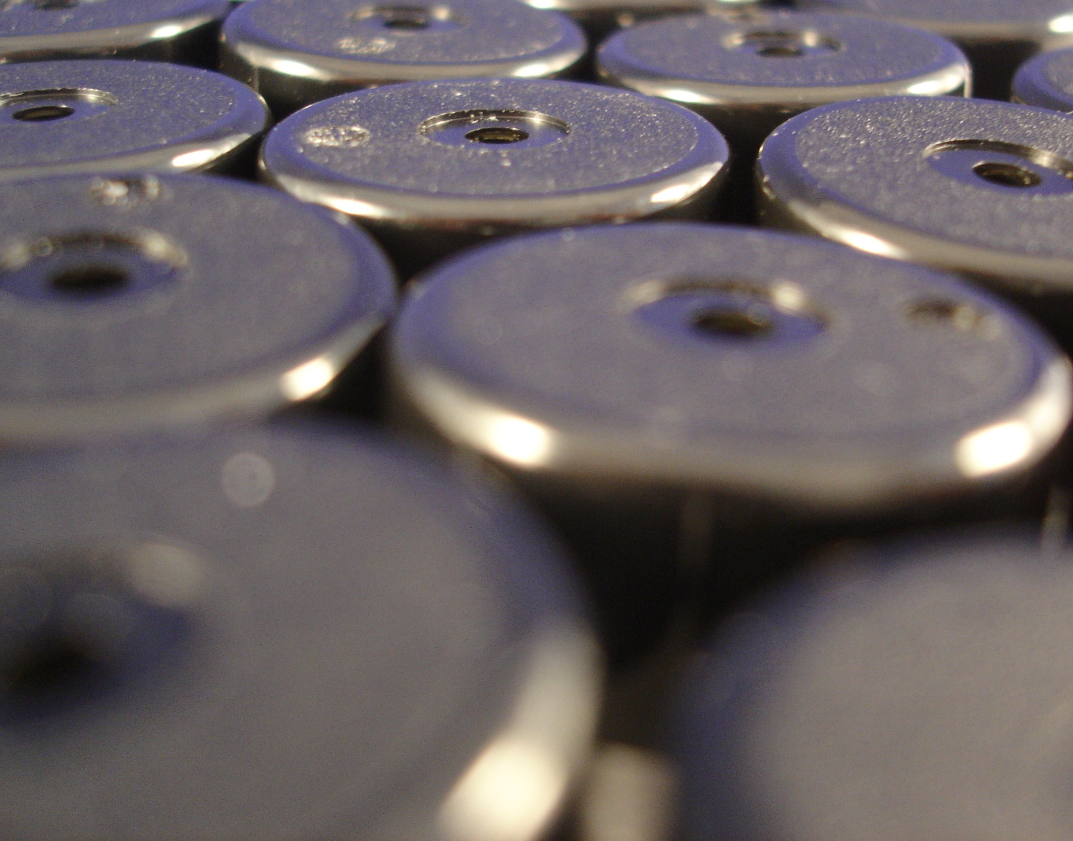 a bunch of silver buttons with holes in them